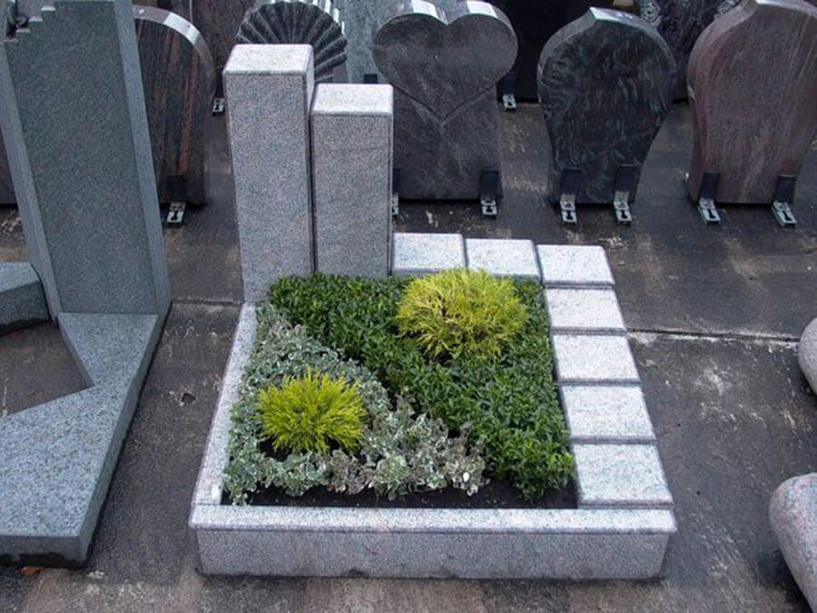 Steinmetzbetrieb und Grabmale Rinteln | Urnengrab mit heller Granit-Einfassung und immergrüner Bepflanzung – schlicht und pflegeleicht