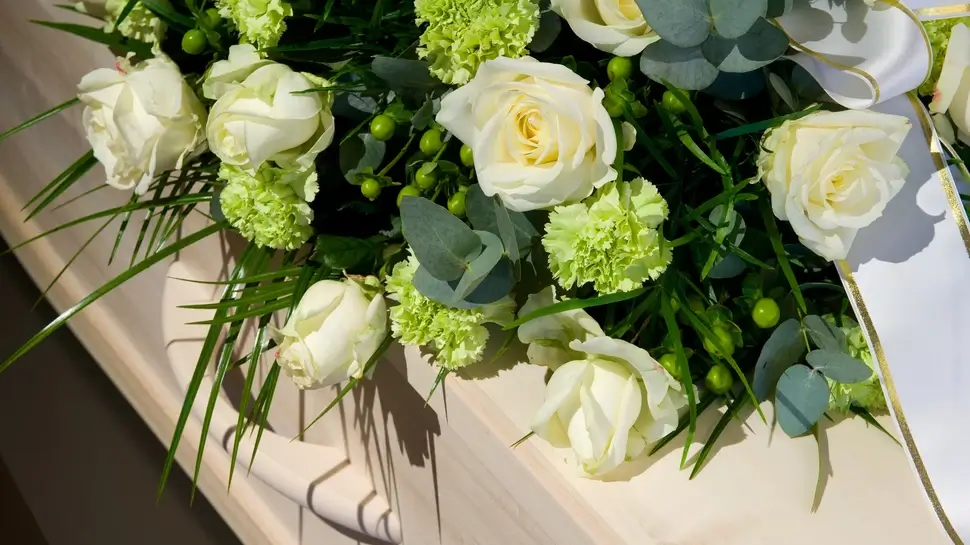 Coffin in morque Waldbestattung Großenkneten | Blumenkranz auf Sarg