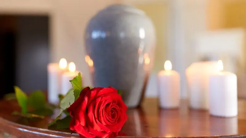 Urne mit Rose und Kerzen