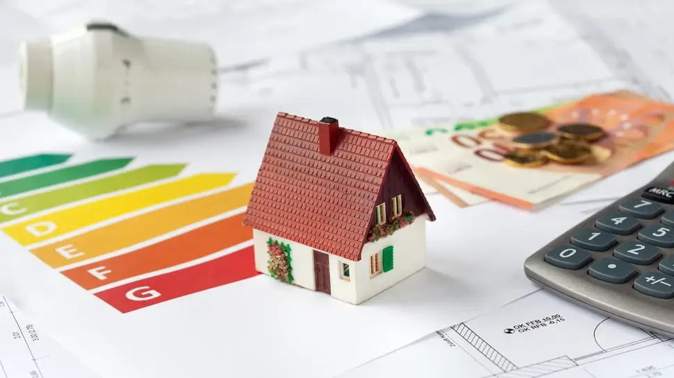 xSymbolbild Energieberatung mit Bauplänen, Rechner, Geld und Thermostat - Beantragung von Fördermitteln zur energetischen Sanierung einer Immobilie Heizungssanierung Uchte | Modellhaus auf Plan zur Heizungssanierung