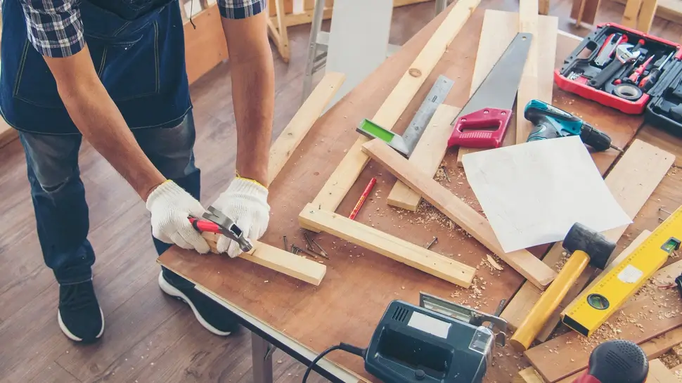 Banner DIY craftsperson asian man working wood heap carpenter objects woodwork desk. Banner Architect man hands ruler measure home improvement. Wood carpenter construction workshop with copy space