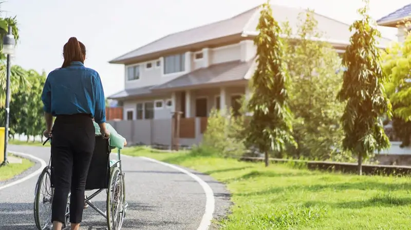 Umfassende Betreuung und Pflege in der Seniorenresidenz Seniorenresidenz Itzehoe | Pflegekraft schiebt Bewohner im Rollstuhl spazieren