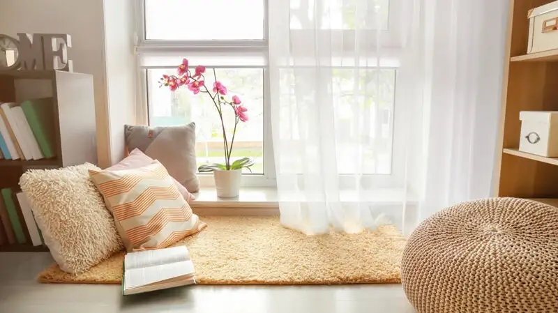 Sonnenschutz Sichtschutz Hamburg | gemütlicher Platz am Fenster mit weißem Vorhang