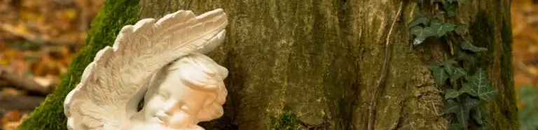 Waldbestattung Garrel | Engel mit Kerze am Baumstamm