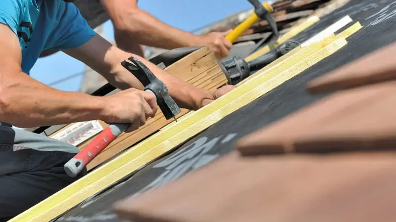 Energetische Dachsanierung Nordfriesland | Dachdecker arbeitet auf dem Dach