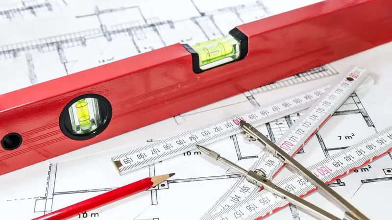 Vermessungsbüro Hamburg Harburg | Wasserwaage, Bleistift, Zollstock und Zirkel auf einem Bauplan/Grundriss Vermessungsbüro Hamburg Harburg | Wasserwaage, Bleistift, Zollstock und Zirkel auf einem Bauplan/Grundriss