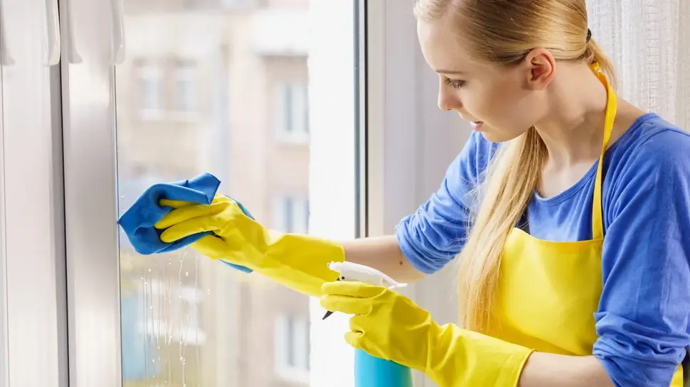 Woman cleaning window at home Fensterreinigung Meppen | Junge Frau putzt Fenster