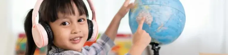 Bilinguale Erziehung Hamburg | Mädchen zeigt auf Globus