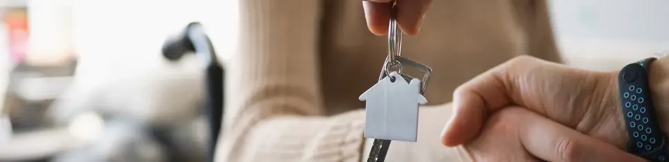 Realtor give keys from new accommodation to woman in wheelchair Barrierefreies Bauen Glückstadt | Frau im Rollstuhl bekommt Wohnungsschlüssel überreicht