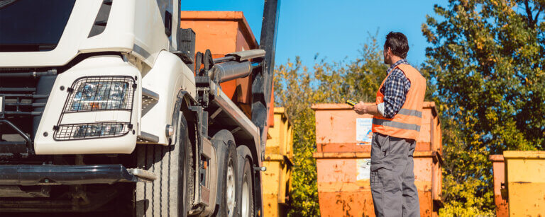 Containerdienst, Kies/Sand und Arbeitgeber mit Zukunft in Springe | Bauarbeiter auf Baustelle lädt Bauschuttcontainer ab
