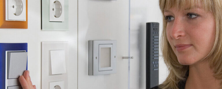 Elektroinstallation Büdelsdorf | Eine Frau, die einen frisch installierten Lichtschalter bedient