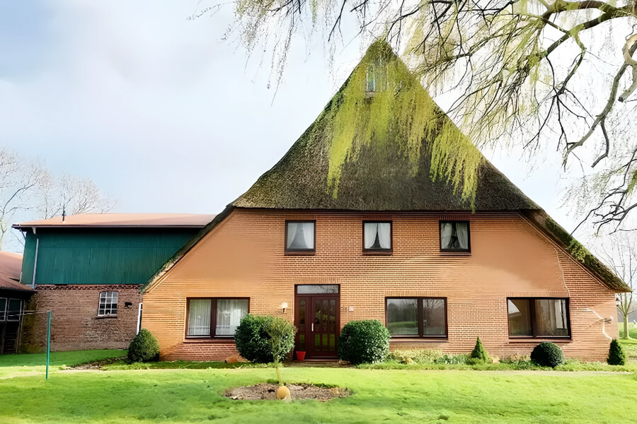 Resthof kaufen in Schleswig Holstein | Frontalaufnahme eines schönen Resthofes mit Spitzdach und Anbau