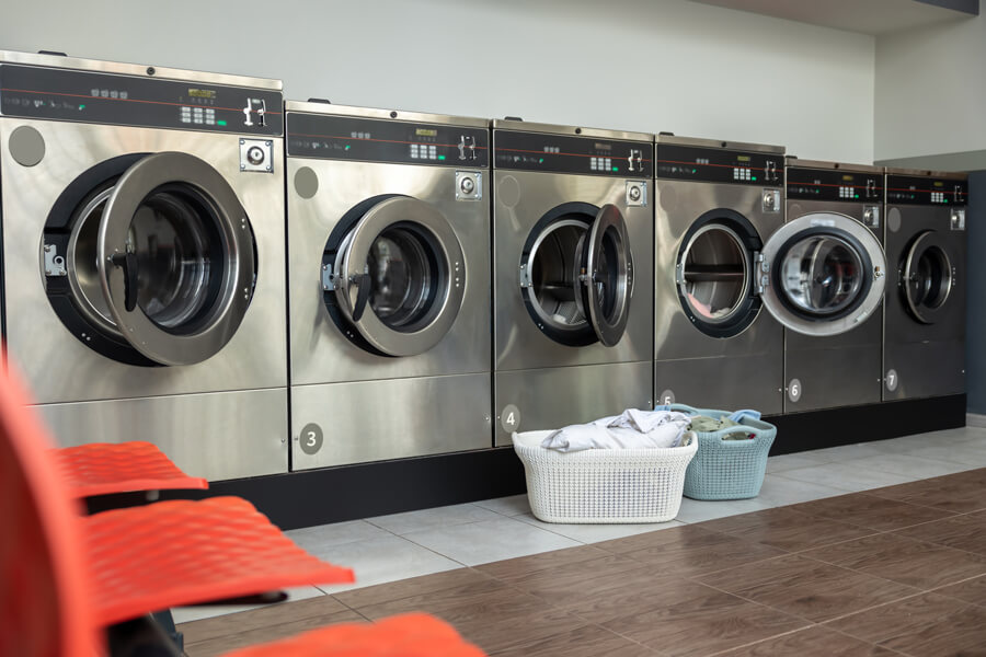 Kundendienst und Service Hausgeräte in Hildesheim | Reihe von Waschmaschinen in einem öffentlichen Waschsalon