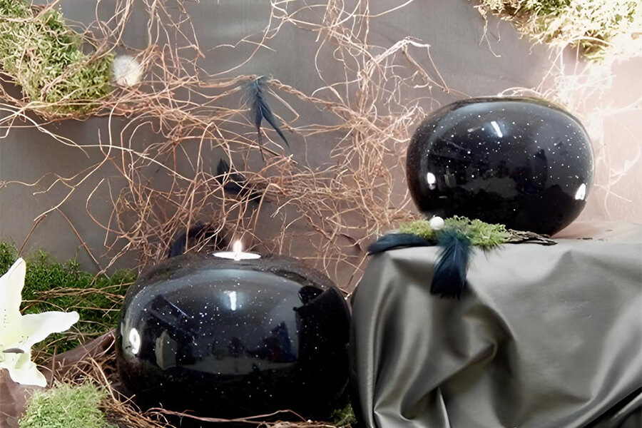 Tierbestatter Bonn | Zwei schwarze Tierurnen mit einem Teelicht