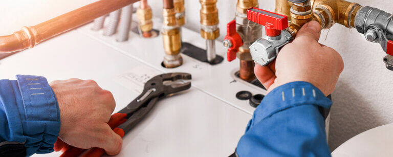 Gas- und Wasserinstallation Bramfeld | Gas- und Wasserinstallateur bei der Druckprüfung und Ventileinstellung eines Leitungssystems.