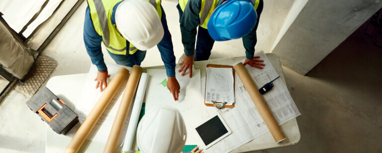Bauunternehmen Blomberg | Bauarbeiter am Tisch bei Besprechung