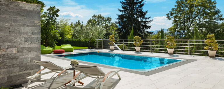 Poolbau in Meppen | Luxuriöser Außenbereich mit Pool und stilvoller Sitzgelegenheit, ideal für entspannte Momente in natürlicher Umgebung