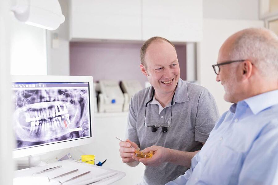 Implantate Nordhorn | Beratungsgespräch zwischen Dr. med. Stefan Kellner und Patient mit Fokus auf eine digitale Röntgenaufnahme