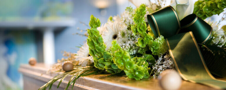 Bestattungsvorsorge Südharz - Niehus Bestattungen | Abschied in Würde – ein mit Blumen geschmückter Sarg symbolisiert den respektvollen Umgang und die persönliche Gestaltung von Trauerfeiern