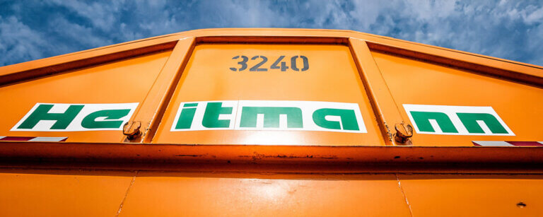 Fettabscheider-Service Elmshorn | Der charakteristische orangefarbene Container der Jan Heitmann GmbH steht für professionelle Entsorgungslösungen