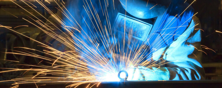 Metallbau und Schlosserei in Göttingen | Schweißarbeiten in einer Werkstatt mit Helm und Arbeitskleidung