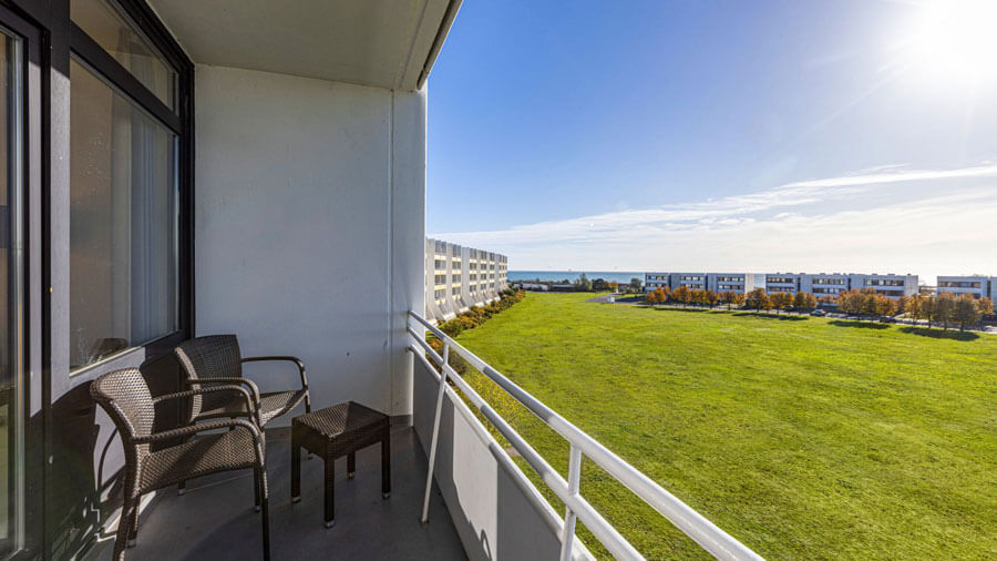 Insel-Hotel auf Fehmarn | Yachthafen: Vom Balkon aus genießen Gäste den weiten Blick über die grüne Küstenlandschaft bis hin zur Ostsee – ideal, um den Tag auf Fehmarn entspannt ausklingen zu lassen