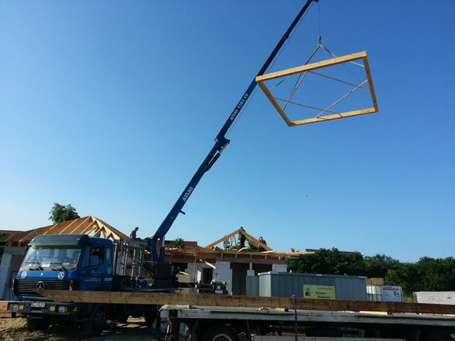 Altbausanierung Papenburg | Mithilfe eines Baukrans wird ein Dachstuhl montiert – ein präziser und sicherer Prozess, der Erfahrung und Fachwissen erfordert, wie sie bei Plaggenborg Zimmerer GmbH vorhanden sind