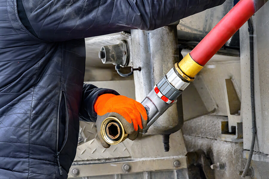 Heizöl in Bad Salzuflen | Ein Mitarbeiter schließt einen Heizölschlauch an den Tankwagen an. Präzise Technik sorgt für eine sichere Befüllung der Heizöltanks