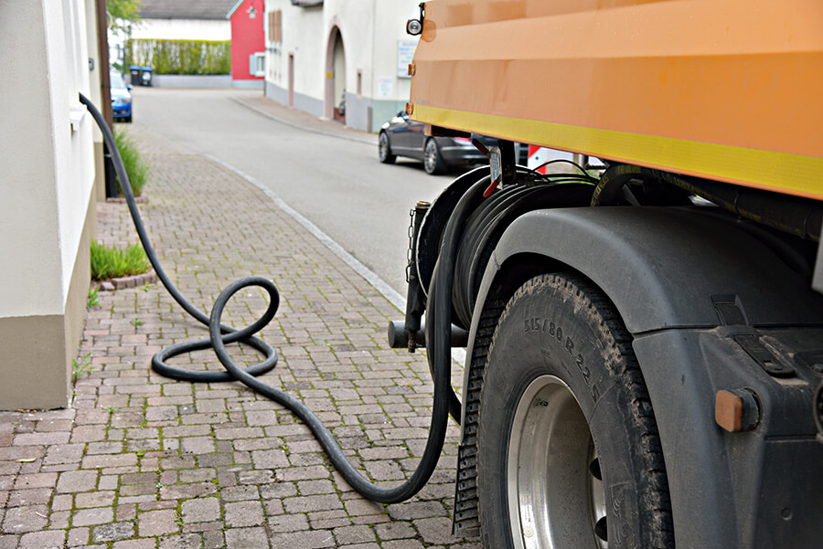 Heizöl in Bad Salzuflen | Ein Tankwagen versorgt ein Wohnhaus in einer Wohnstraße mit Heizöl. Moderne Liefermethoden ermöglichen eine zuverlässige Energieversorgung auch in engen Straßen
