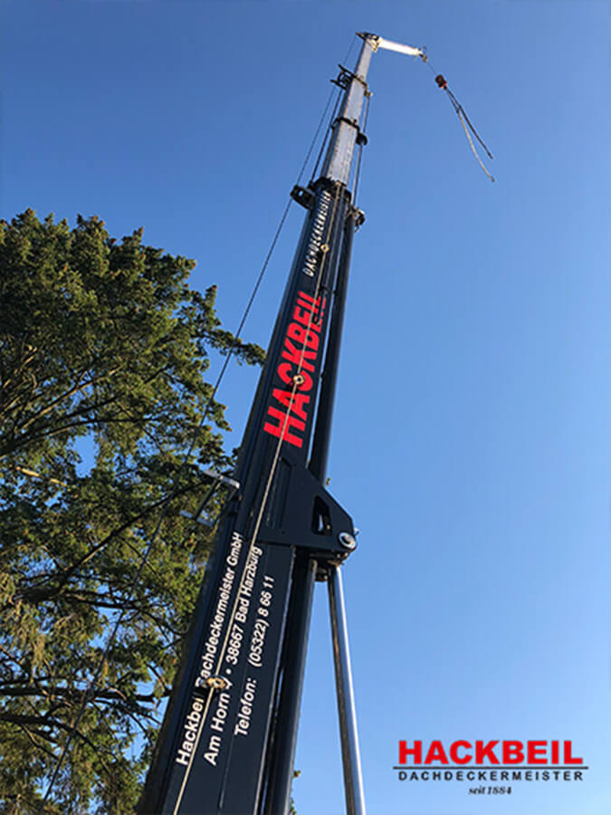 Dachdecker in Bad Harzburg | Der Firmenkran der Hackbeil Dachdeckermeister GmbH im Einsatz – Dachdeckertradition seit 1884 in Bad Harzburg