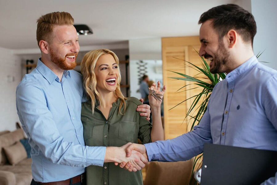 Immobilienmakler, Immobilienbewertung und Immobilienfinanzierung vom Profi für Heiligenhafen, Fehmarn und Umgebung | Schlüsselübergabe an ein glückliches Paar durch einen Makler der S-Immobiliengesellschaft Holstein.