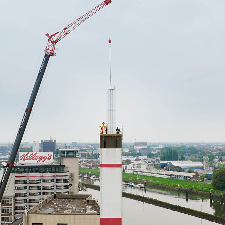 Schornsteintechnik Dortmund | Bei industriellen Großprojekten wie am Kellogg's-Werk in Bremen kommt schwere Krantechnik zum Einsatz, um neue Schornsteinelemente millimetergenau zu positionieren